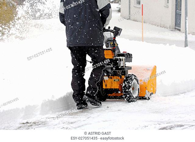 a man admits snow with a snowblower