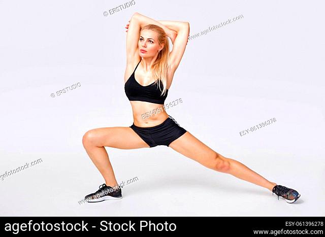 beautiful sporty woman in sportswear does exercises. stretching