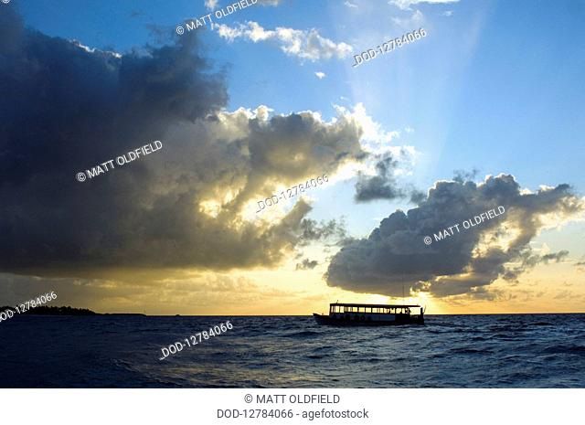 Maldives, Boat in sea at sunset