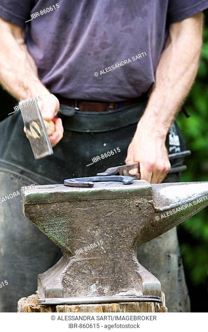 Blacksmith shoding a horse, forming the hot iron on an anvil, North Tyrol, Austria, Europe