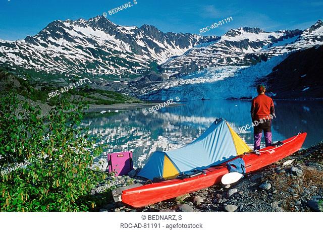 Hiker with tent and kayak at Shoup Glacier Prince William Sound Alaska USA