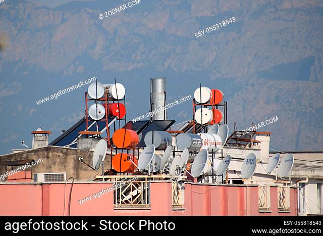 Antalya, Turkey - May 19, 2019: Steel barrels of boilers with water on the roof of a building to heat water. Water heating by the sun and solar panels