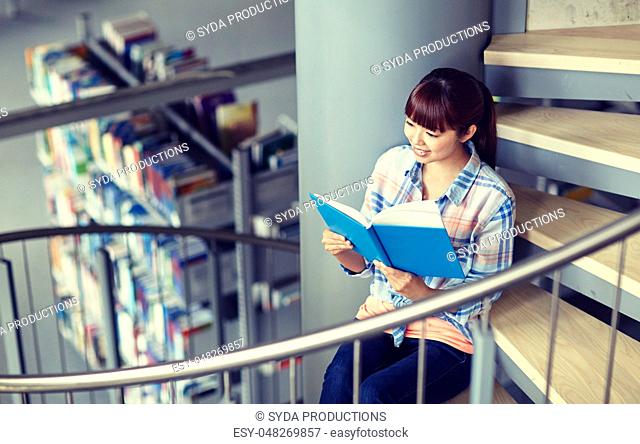 high school student girl reading book at library