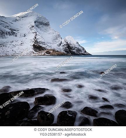 Winter mountain peaks rise over Bunes beach, Moskenesøy, Lofoten Islands, Norway