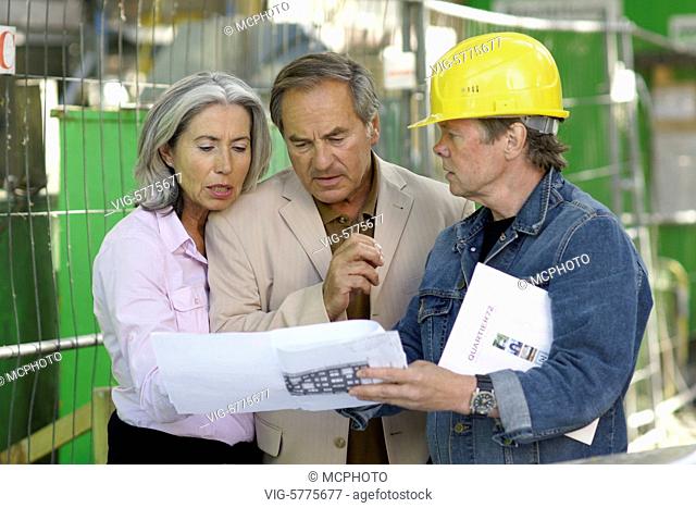 Germany, HAMBURG, 30.06.2008, Ein aelteres Paar besichtigt eine Baustelle und lasst sich vom Architekten den Grundriss erklaeren
