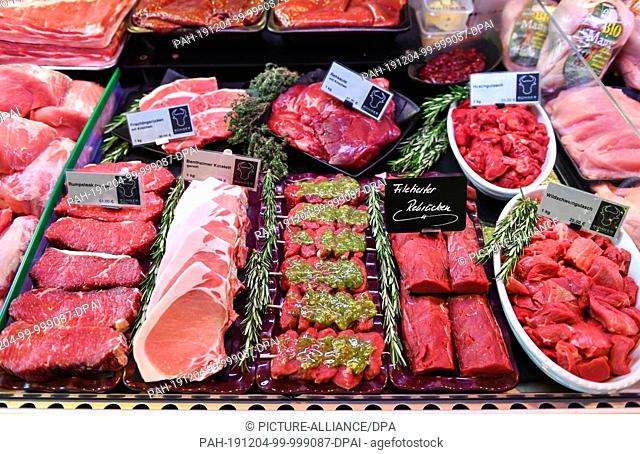 03 December 2019, Berlin: Fresh meat such as rump steak, leg of venison, saddle of venison and wild boar goulash are on display in the Jens-Uwe Bünger butcher's...