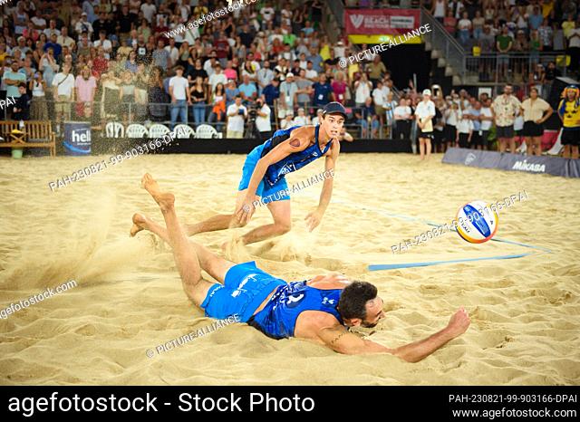 20 August 2023, Hamburg: Volleyball/Beach: Beach Pro Tour, Final, Italy - Sweden. The Italians Samuele Cottafava (l-r) and Paolo Nicolai try to save a ball...