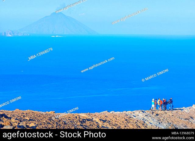 People enjoying views of Stromboli island from Gran Cratere rim, Vulcano Island, Aeolian Islands, Sicily, Italy