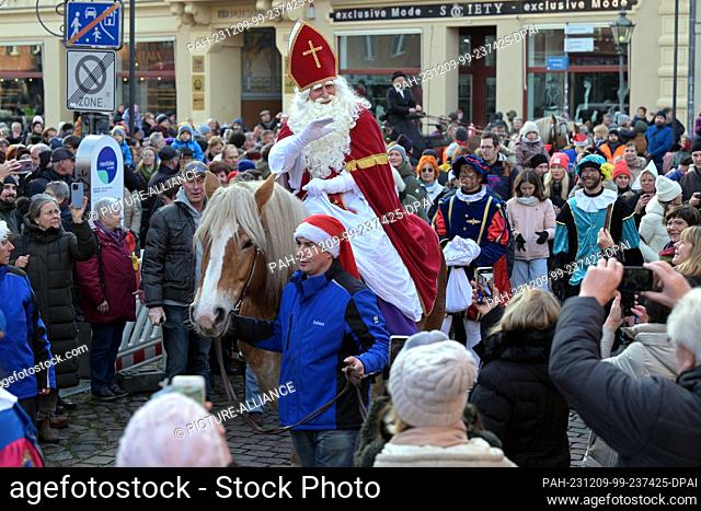09 December 2023, Brandenburg, Potsdam: The historic Dutch Santa Claus figure Sinterklaas rides into Potsdam's Dutch Quarter to open the local Christmas market