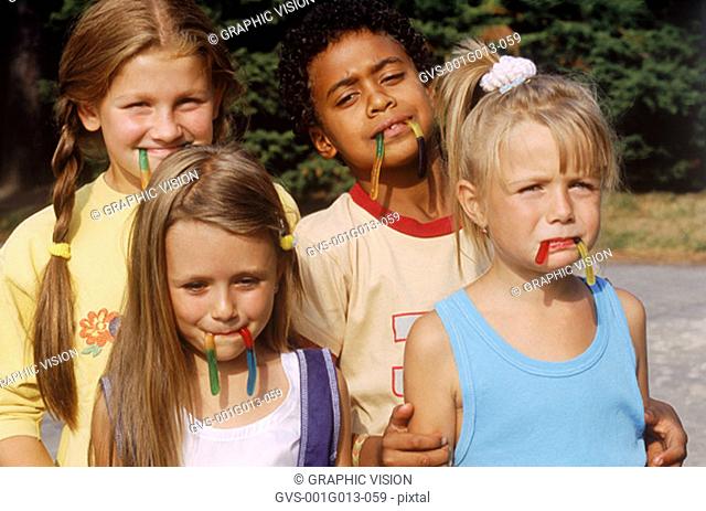 Group of young children with candy in their mouth