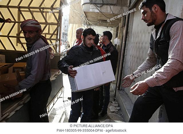 Volunteers unload aid material delivered to the rebel-held city of Douma, Eastern Ghouta province, Syria, 05 March 2018. A 46-truck convoy includes UN agencies