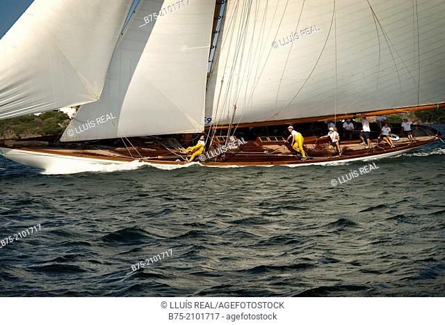 Classic sailboat in a regatta with sailors in the background at the Port Mahon, Menorca, Balearic Islands, Spain