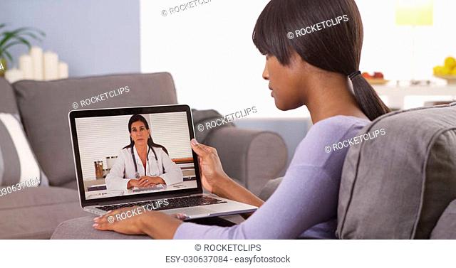 African woman video chatting with doctor