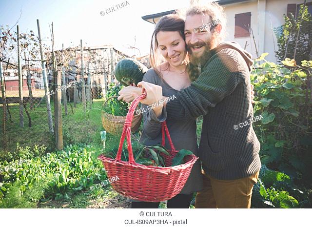 Young couple with basket of homegrown vegetables