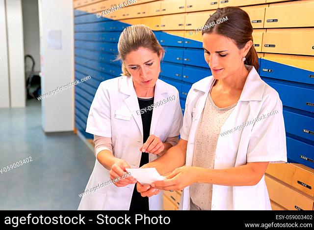 A pharmacist consults with her assistant about a medical prescription