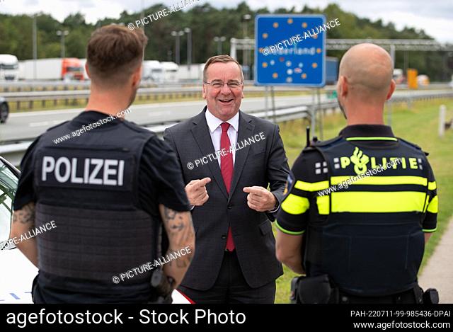 11 July 2022, Lower Saxony, Bad Bentheim: Lower Saxony's Interior Minister Boris Pistorius (SPD) talks with a German (l) and a Dutch (r) police officer from the...