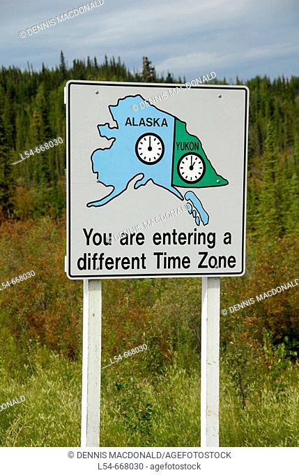 Time zone change sign marker at border of Yukon Territory Canada and Alaska AK U S United States Alaska Highway ALCAN Al-Can