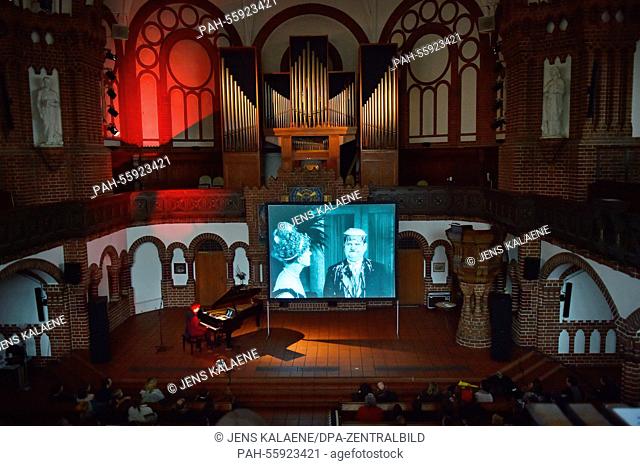 dpa-EXCLUSIVE - Pianist Carsten-Stephan Graf von Bothmer performs on stage (L, back) in front of screen which displays the Silent film comedians Stan Laurel and...