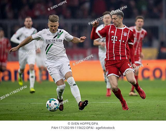 Robert Lewandowski (r) of Munich and Matthias Ostrzolek of Hannover vie for the ball during the German Bundesliga football match between Bayern Munich and...
