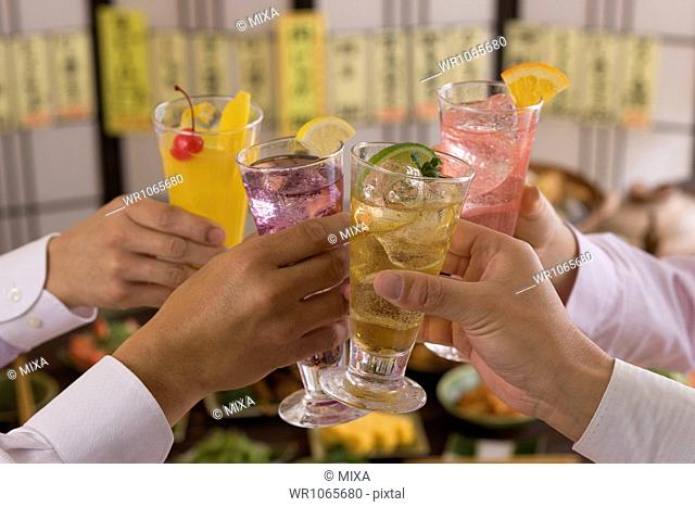 Four People Toasting with Various Cocktails at Izakaya