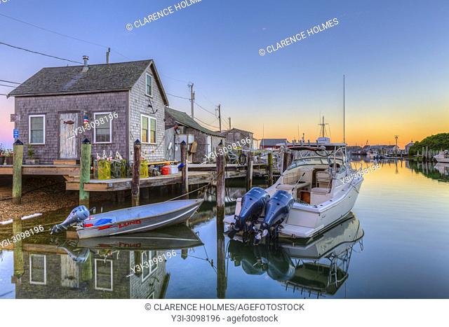 The commercial fishing village of Menemsha and boats docked in Menemsha Basin under a colorful sky during morning twilight, in Chilmark