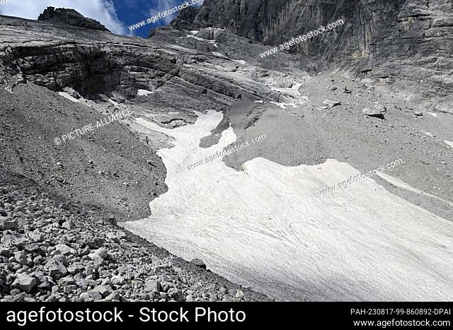 PRODUCTION - 11 August 2023, Bavaria, Ramsau: Debris and remnants of snow lie on the Watzmann Glacier. Researchers give them only a few more years: The last...