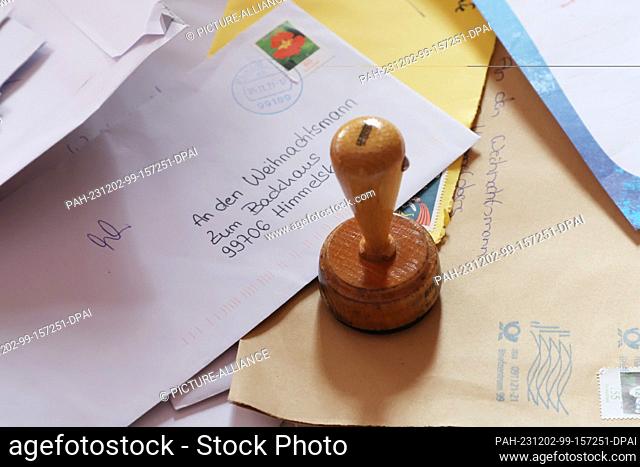 02 December 2023, Himmelsberg: Letters and a postmark lie on a table in the Christmas post office for the open day at the Himmelsberg Christmas post office