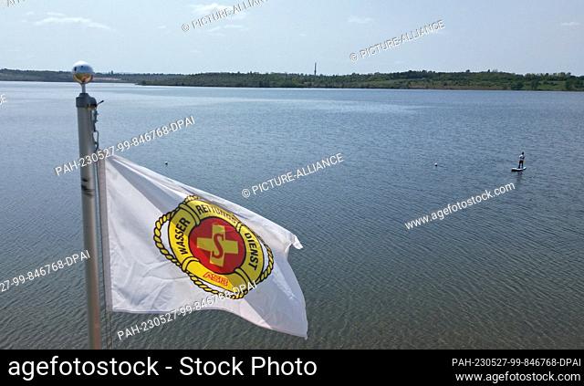 27 May 2023, Saxony-Anhalt, Aschersleben: A water rescue flag flies at the water rescue station at Lake Concordia (shot by drone)
