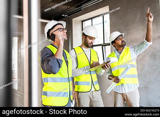 male architects in helmets working at office