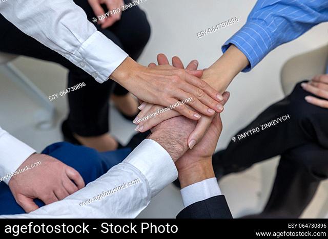 Psychological support. Close up of people holding hands during therapy session