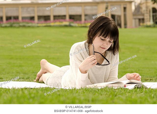 Young woman reading a book in a park