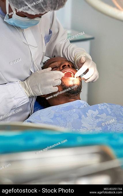 Female dentist examining teeth of a man