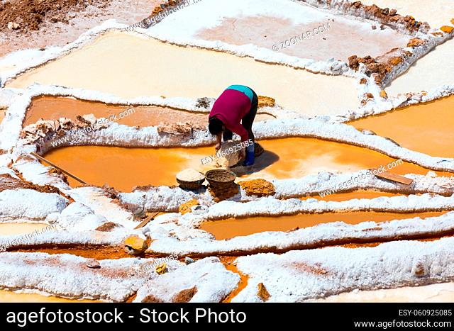 Moray Peru September 14 2018 A woman is working in the saltpans of Moray in a sunny day. The extracted salt is sold to cattle farmers