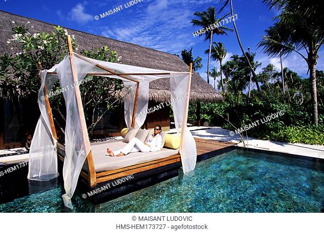 Maldives, North Malé Atoll, One and Only Reethi Rah Hotel, girl relaxing on the edge of the private swimming-pool of her beach villa