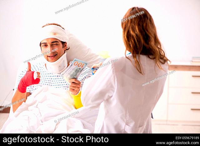 Young doctor examining injured patient
