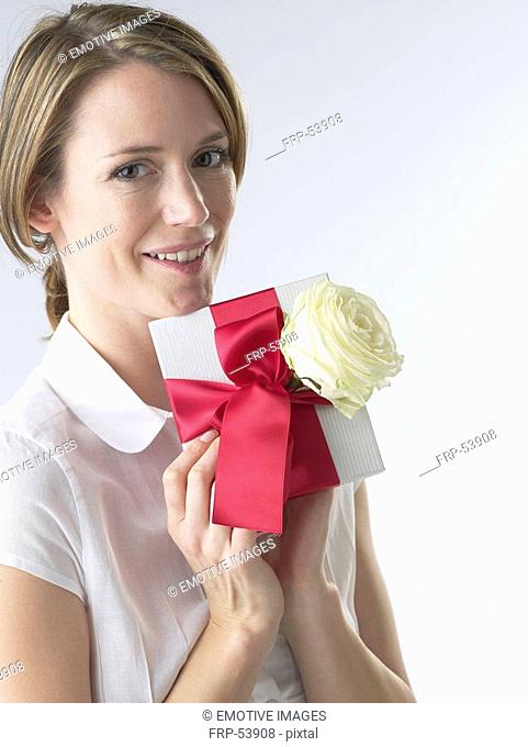 Woman with a gift and white rose blossom