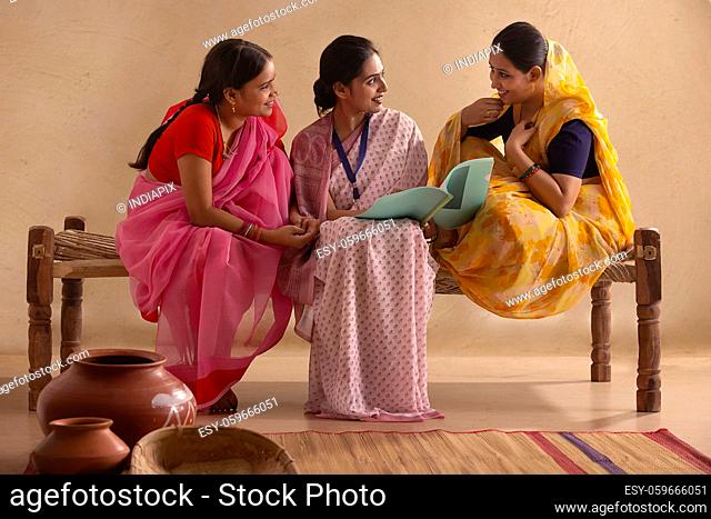 A lady officer talking to two rural women