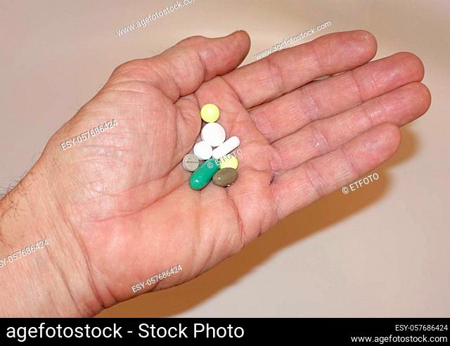 Opened hand with several tablets - symbolic image for drug addiction