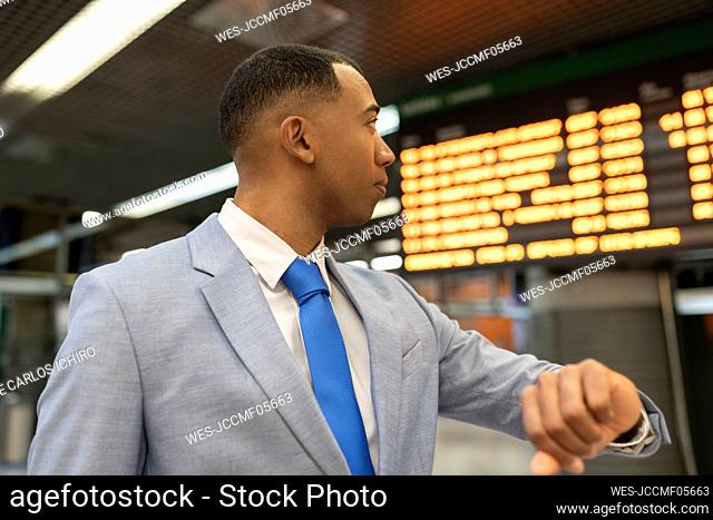 Businessman checking time waiting at train station