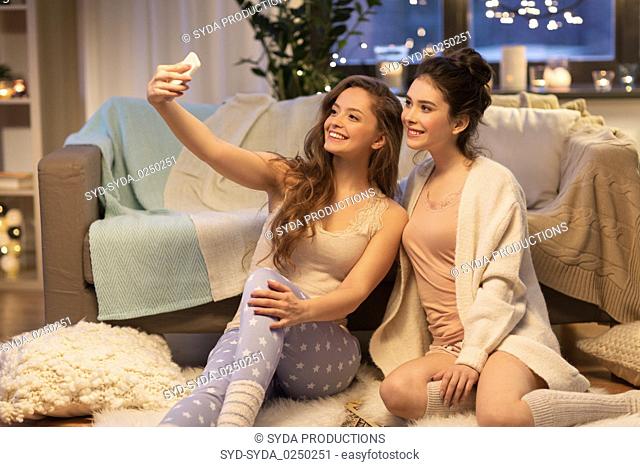 female friends taking selfie by smartphone at home
