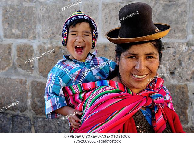Peruvian woman wearing national clothing and holding his child in Cusco, Peru, South America