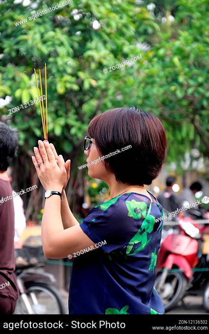 HO CHI MINH CITY, VIET NAM, MAY 29, 2018: Woman pray and burn incense in full moon day at pagoda, a traditional culture Buddhist at Vietnam