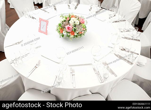table setting, festive round tables ready for guests. Beautifully organized event. floral arrangement in the center. fresh flowers cut-off