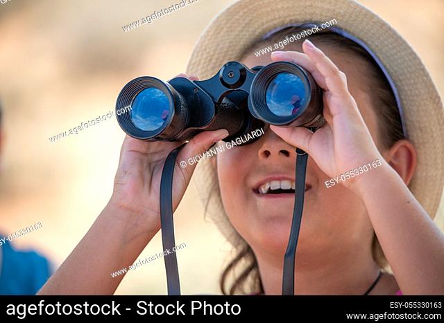 Young girl using binoculars mesmerized by national park landscape