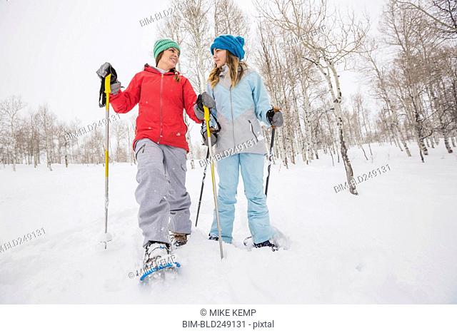 Caucasian mother and daughter snowshoeing