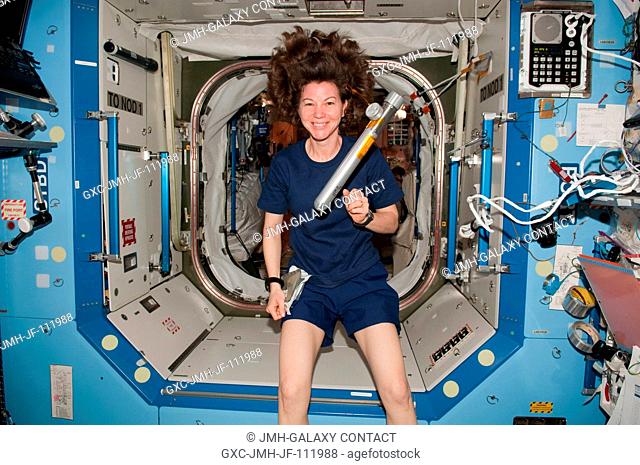 NASA astronaut Cady Coleman, Expedition 26 flight engineer, is pictured near a Japanese-designed metal cylinder floating freely in the Destiny laboratory of the...
