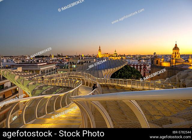 View over Sevilla from Metropol Parasol at sunset, curved wooden construction, Cathedral of Sevilla with tower La Giralda