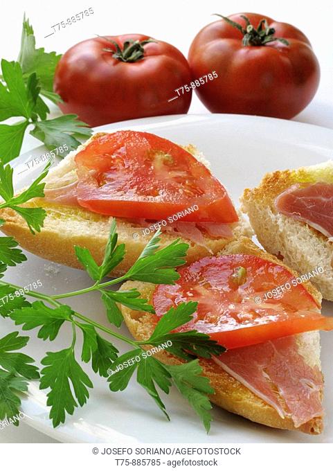Toasted bread with olive oil, ham and tomato