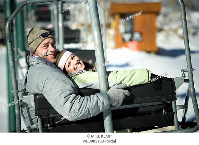 Portrait of an adult couple sitting on a ski lift
