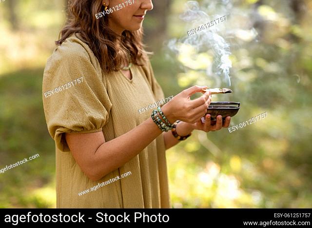 woman with palo santo performing magic ritual